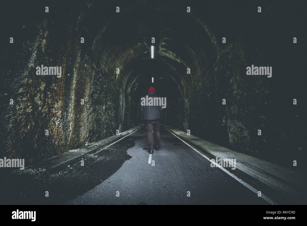 Senior uomo a camminare in illuminato ciclo pedonale tunnel Foto Stock