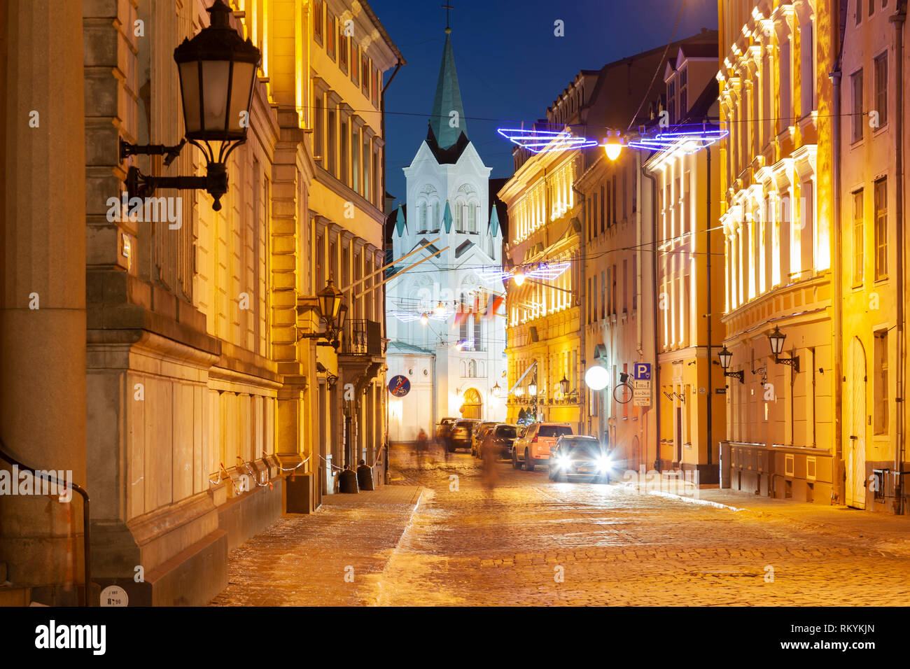 Sera d'inverno in Riga old town con la Madonna Addolorata in distanza. Foto Stock