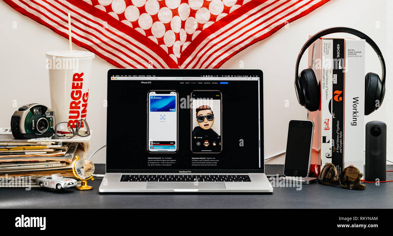 LONDON, Regno Unito - Sep 13, 2018: Creative stanza tavolo con il browser Safari su laptop MacBook Pro vetrina per i computer Apple più recenti sito web iPhone Xs smartphone con memoji espressive e faceid avanzate Foto Stock