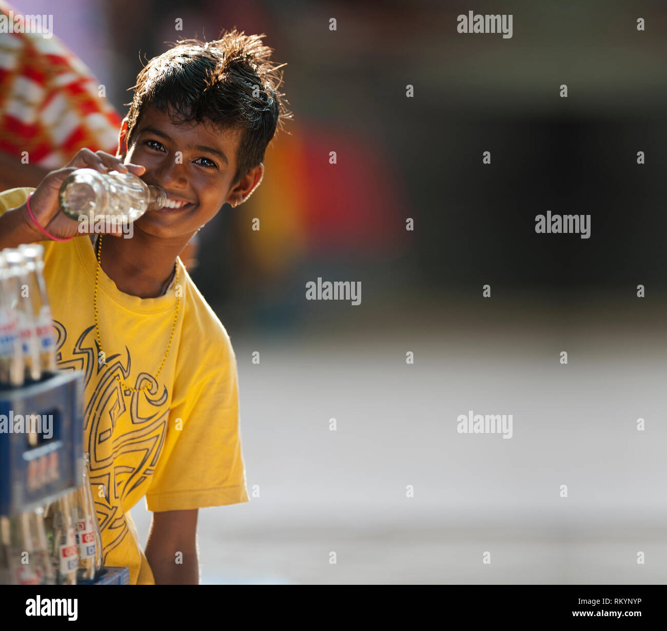 Ragazzo indiano di bere dalla bottiglia di bevanda fredda in India. Foto Stock