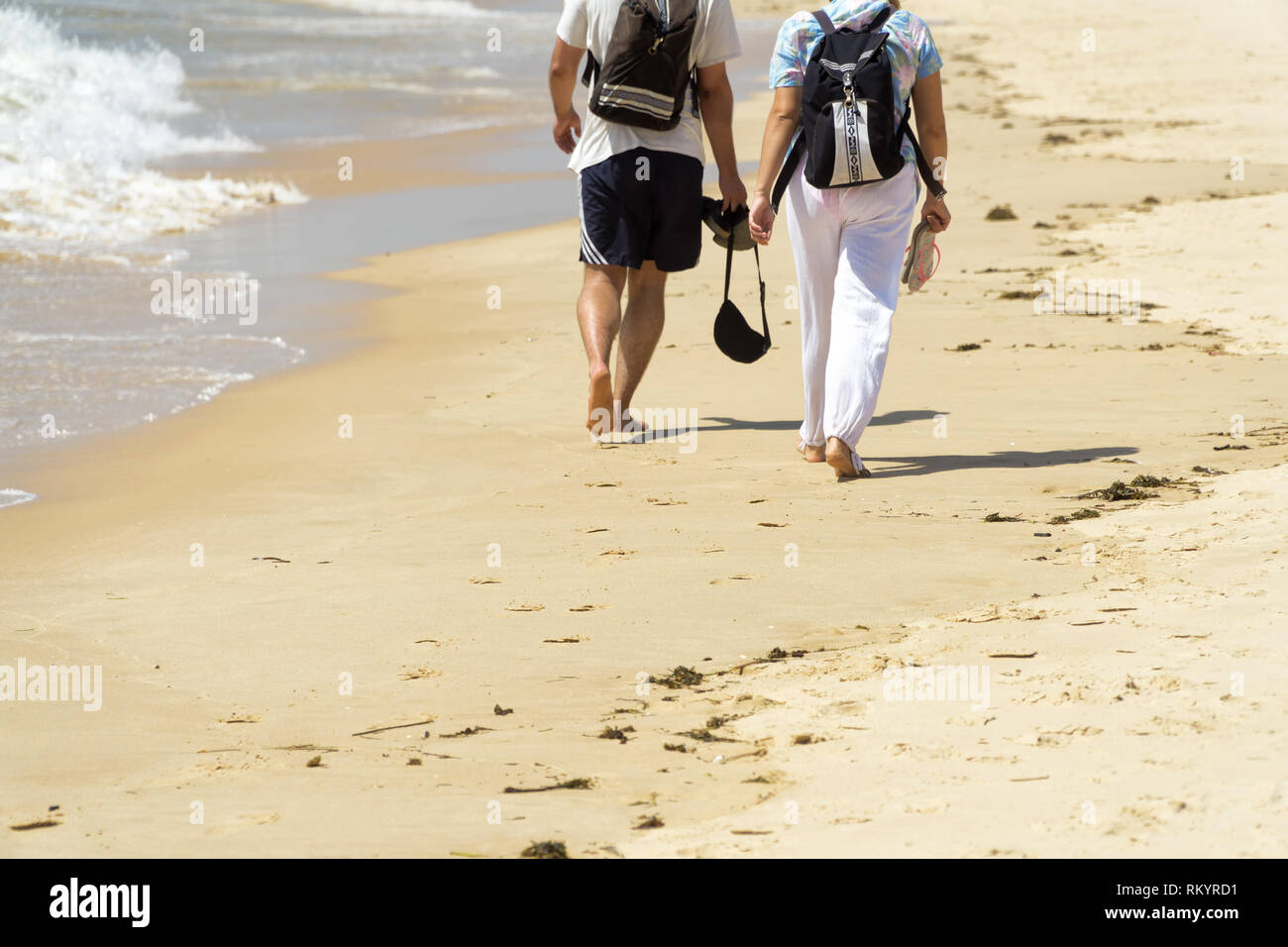 Paio di camminare sulla spiaggia in estate giornata di sole. Foto Stock