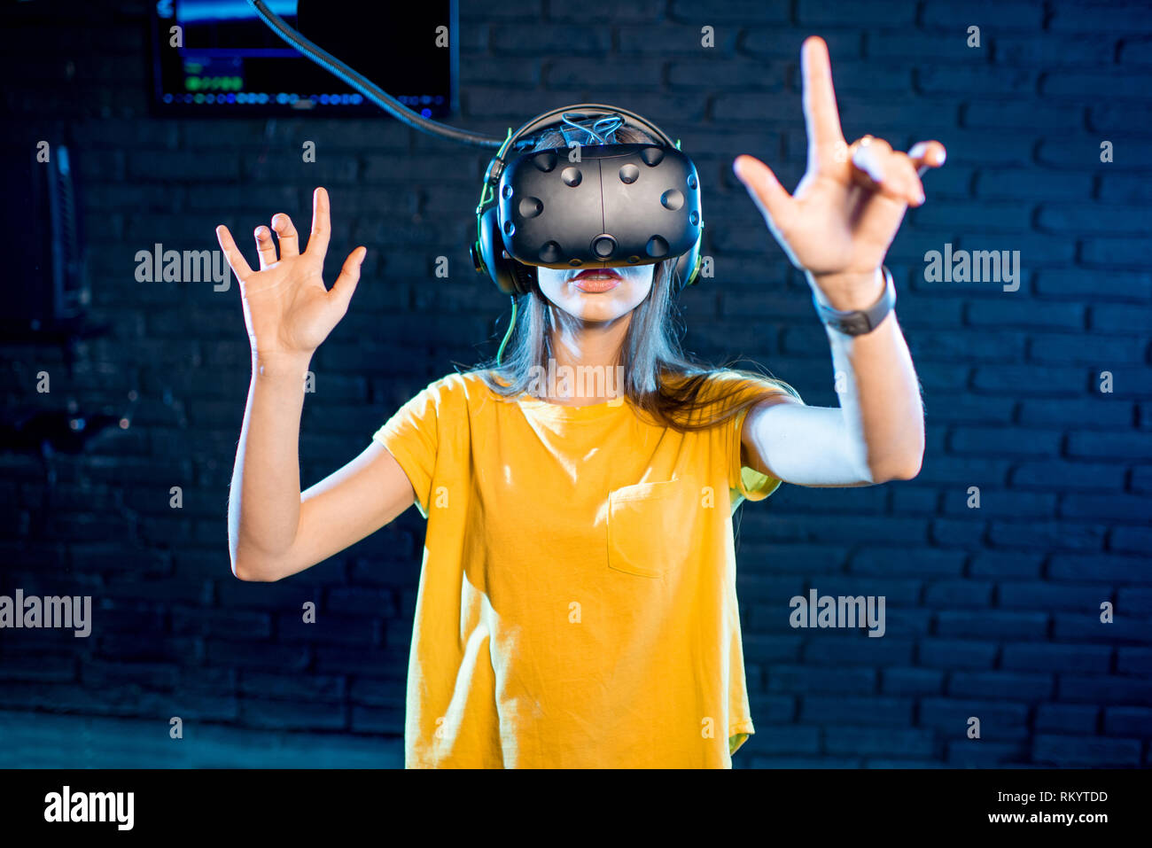 Donna di toccare la realtà virtuale spazio utilizzando cuffie VR nella riproduzione di camera Foto Stock