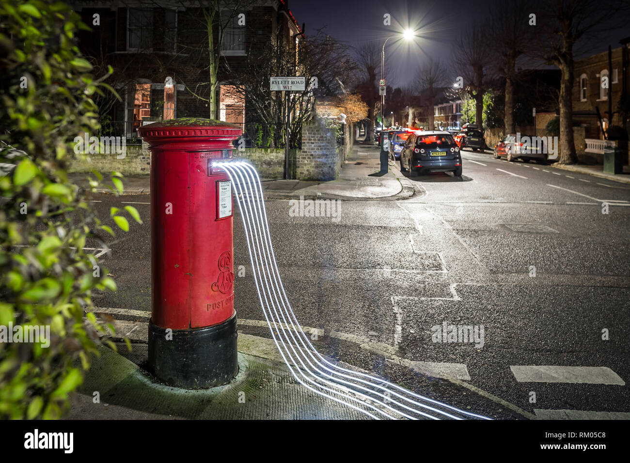 Postbox e sentieri di luce nel sobborgo di Londra, Regno Unito Foto Stock