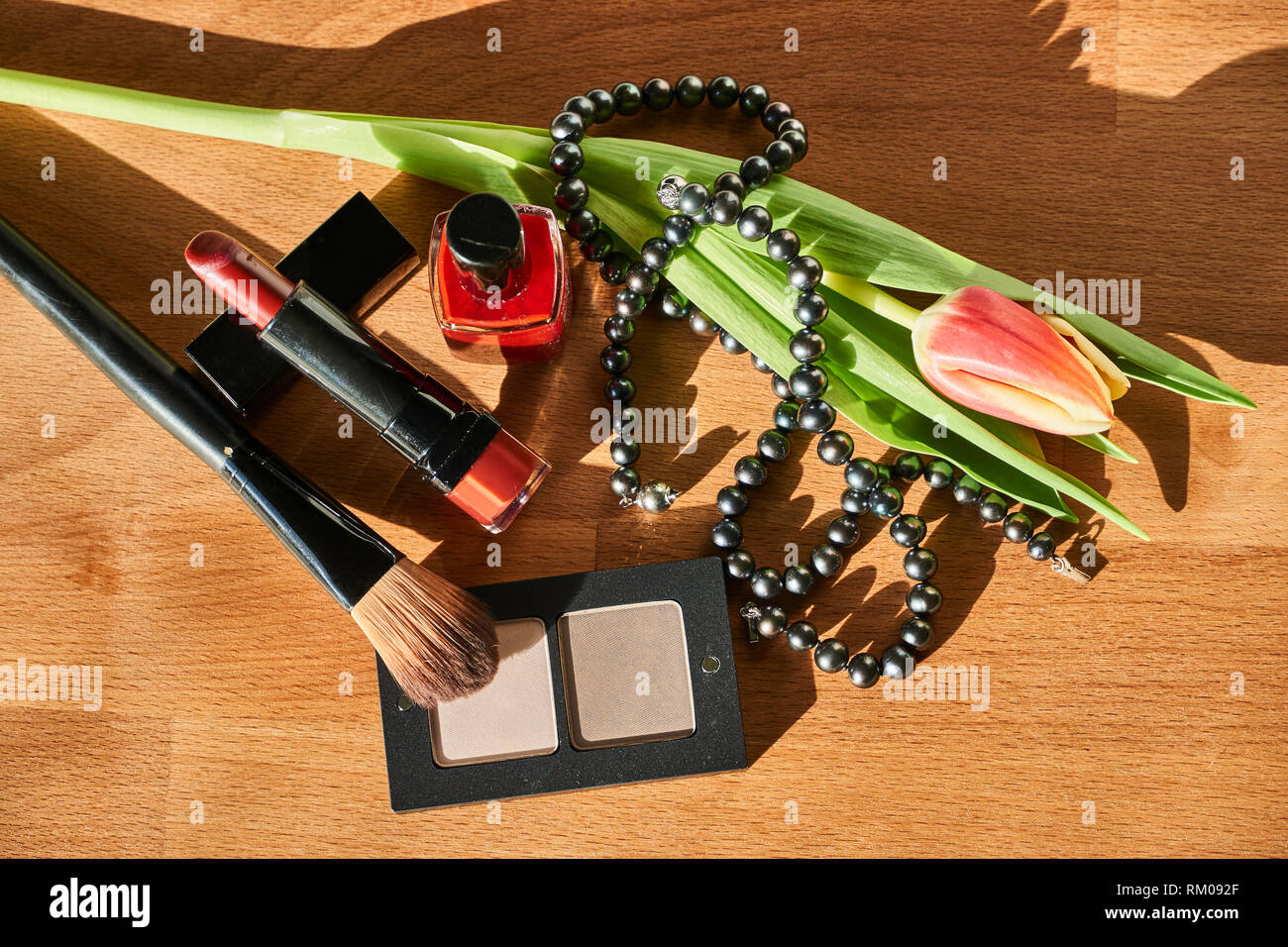 Cosmetici, collana di perle e tulip su un tavolo di legno Foto Stock