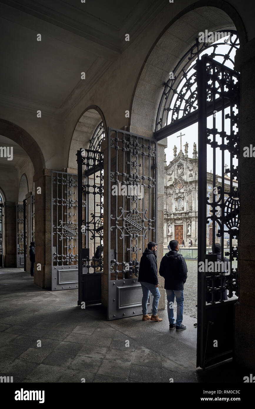 La gente si ripara dalla pioggia sotto i portici del Rettorato dell'università della città di Porto, Portogallo, Europa Foto Stock