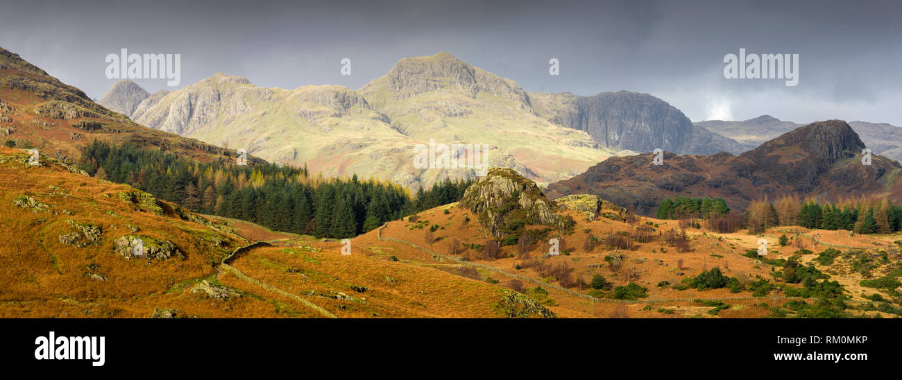 In autunno la luce del sole su The Langdale Pikes nel Parco Nazionale del Distretto dei Laghi, Cumbria, Inghilterra. Foto Stock