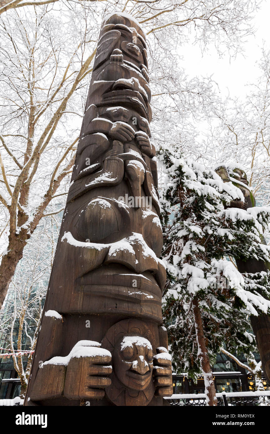 Seattle, Washington: Duane Pasco il totem 'SONU e Raven' è spolverato di neve fresca in Occidental quadrato come una forte tempesta di neve ricopre la città. Foto Stock