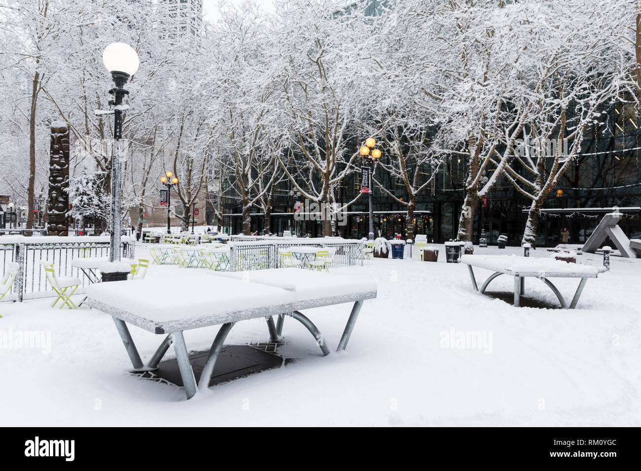 Seattle, Washington: tavoli da ping-pong in Occidental Square rimanere inutilizzate come una forte tempesta di neve ricopre la città in sei pollici di neve. Foto Stock