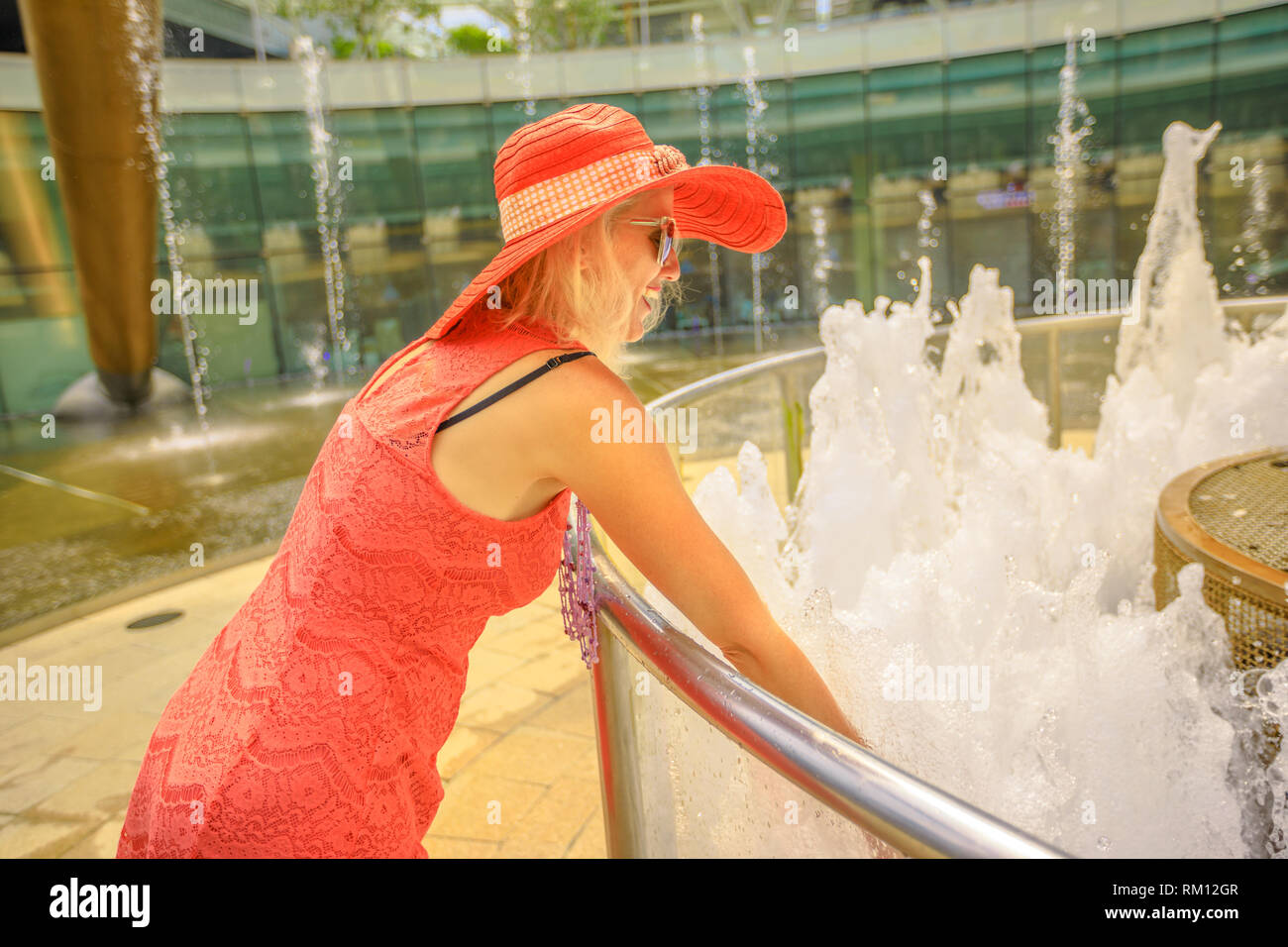 Felice tourist godendo al più grande fontana nel mondo. Fontana della Ricchezza a Suntec Tower la più grande fontana in Singapore. Lo stile di vita della donna con Foto Stock