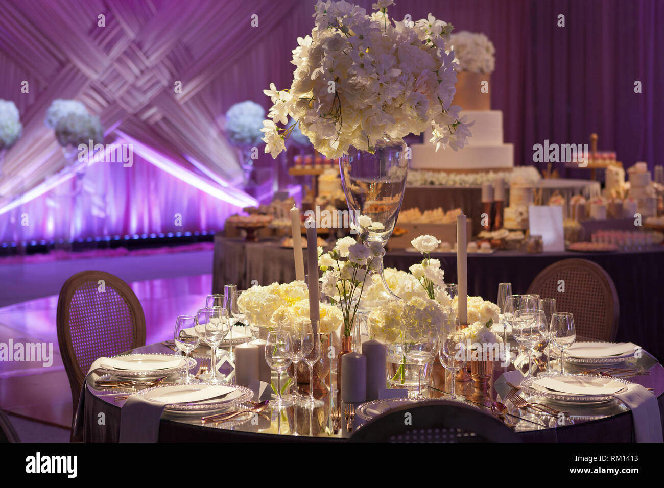 Moody ambiente retroilluminato di un ricevimento di matrimonio, lusso elegante Impostazione tabella Foto Stock