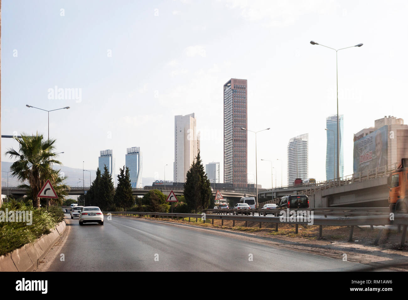 Izmir, Turchia - 8 Agosto 2018: Gee perla skyscrapper, Mistral skyscrapper e torri Folkart vista dalla strada di Ankara con il traffico di Izmir, Turchia. Foto Stock