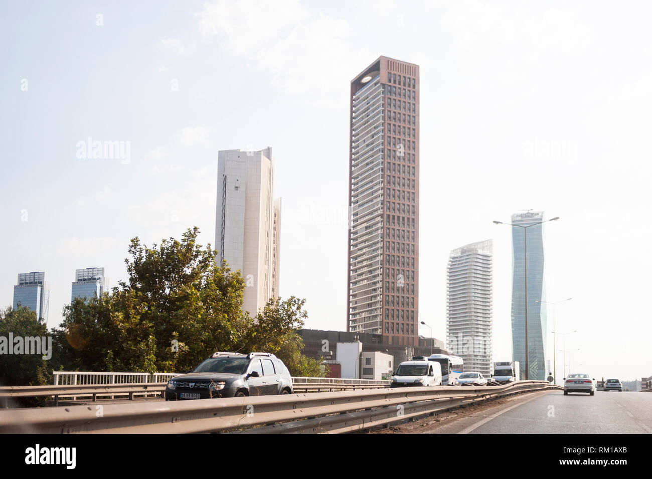 Izmir, Turchia - 8 Agosto 2018: Gee perla skyscrapper, Mistral skyscrapper e torri Folkart vista dalla strada di Ankara con il traffico di Izmir, Turchia. Foto Stock