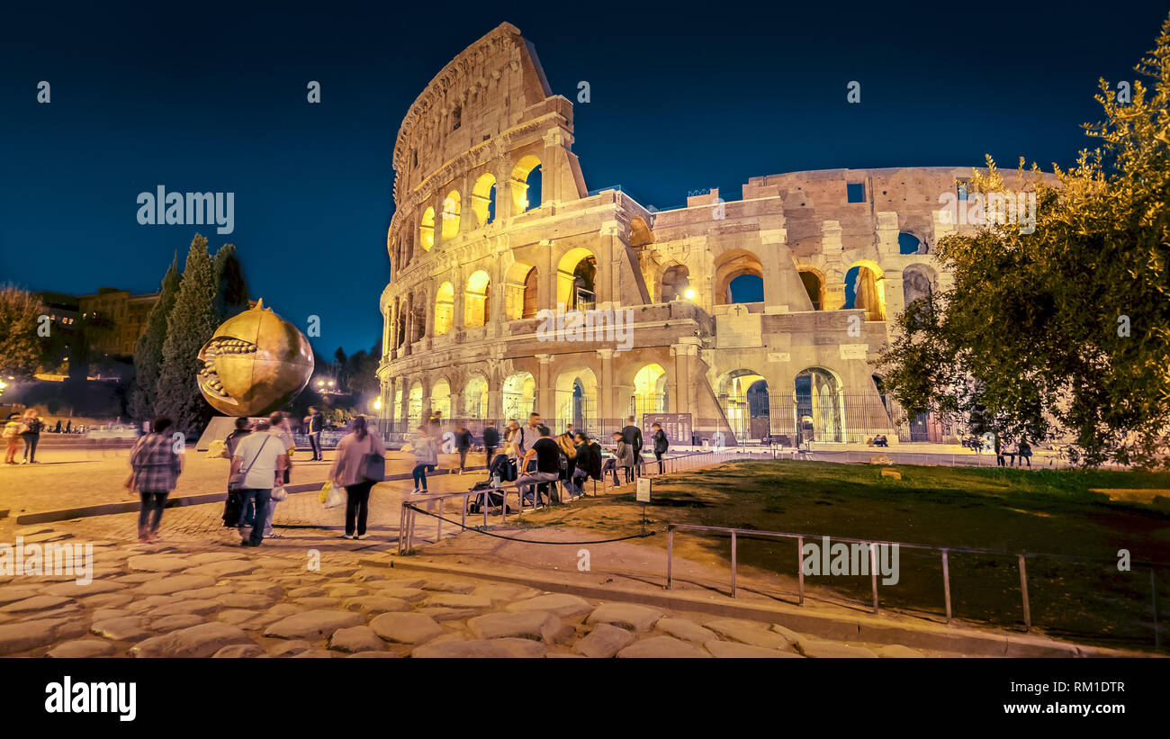 Colosseo romano e i turisti di notte a Roma, Italia, persone sfocato Foto Stock