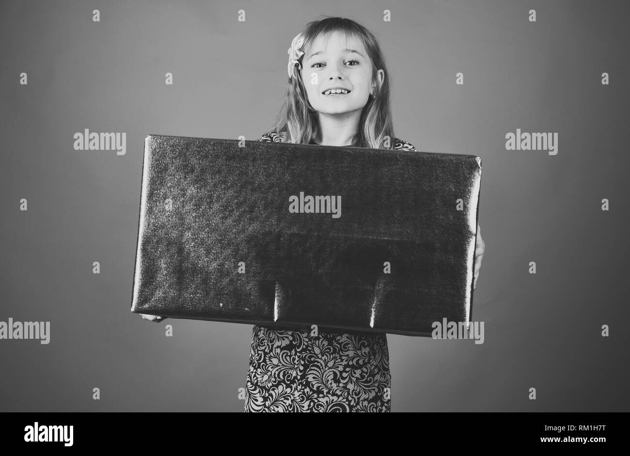 Infanzia e felicità, confezione regalo. Bambino ragazza con presente pack, cyber lunedì. Compleanno e Natale. Piccola ragazza con pacchetto shopping venerdì nero Foto Stock