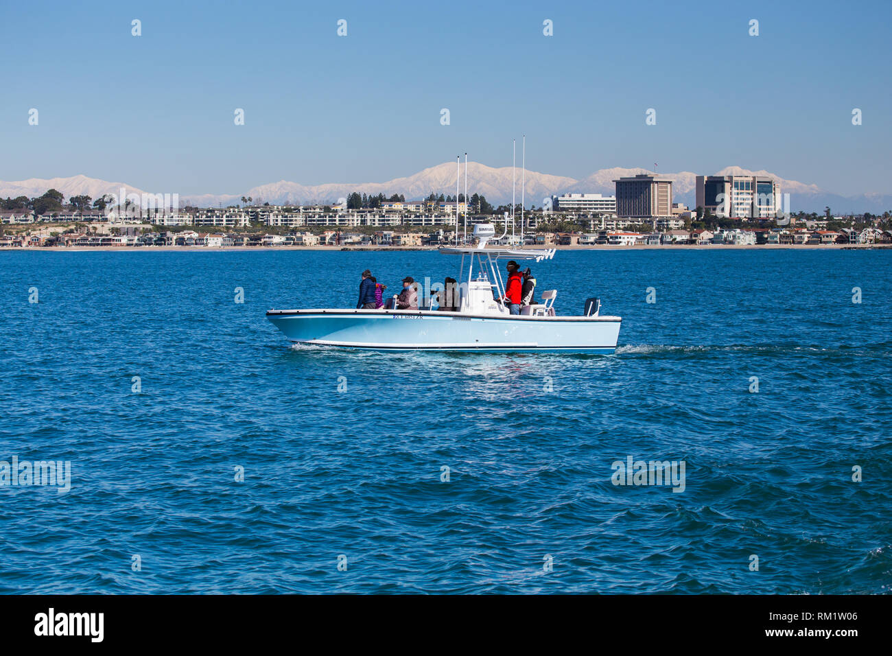 Piccolo parcheggio privato whale watching battello al largo di Newport Beach in California con la Hoag Hospital & cime Montagne di San Gabriel in background Foto Stock