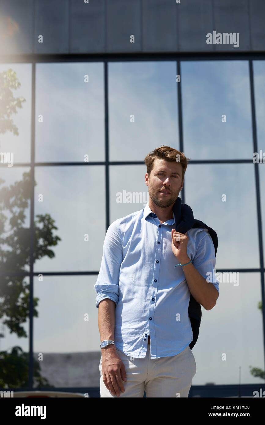 Ritratto di Youtuber Axel Sprenger nella parte anteriore del vetro  riflettente di architettura albero, indossando vestiti business. Il  contrasto nella vita della città e natura. In Foto stock - Alamy