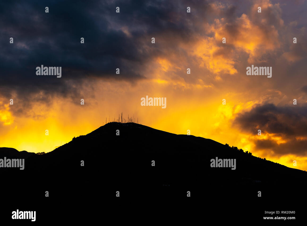 Fotografia paesaggio di uno dei picchi del vulcano Pichincha al tramonto con nuvole drammatico nella città di Quito, Ecuador. Foto Stock