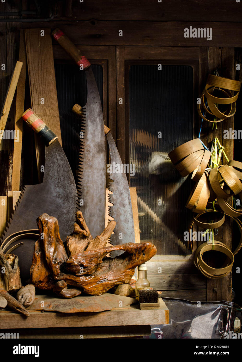 Grandi seghe, radica di legno e varie attrezzature per la lavorazione del legno nella parte anteriore di un vecchio negozio nel villaggio di Umaji, prefettura di Kochi, Shikoku Giappone Foto Stock