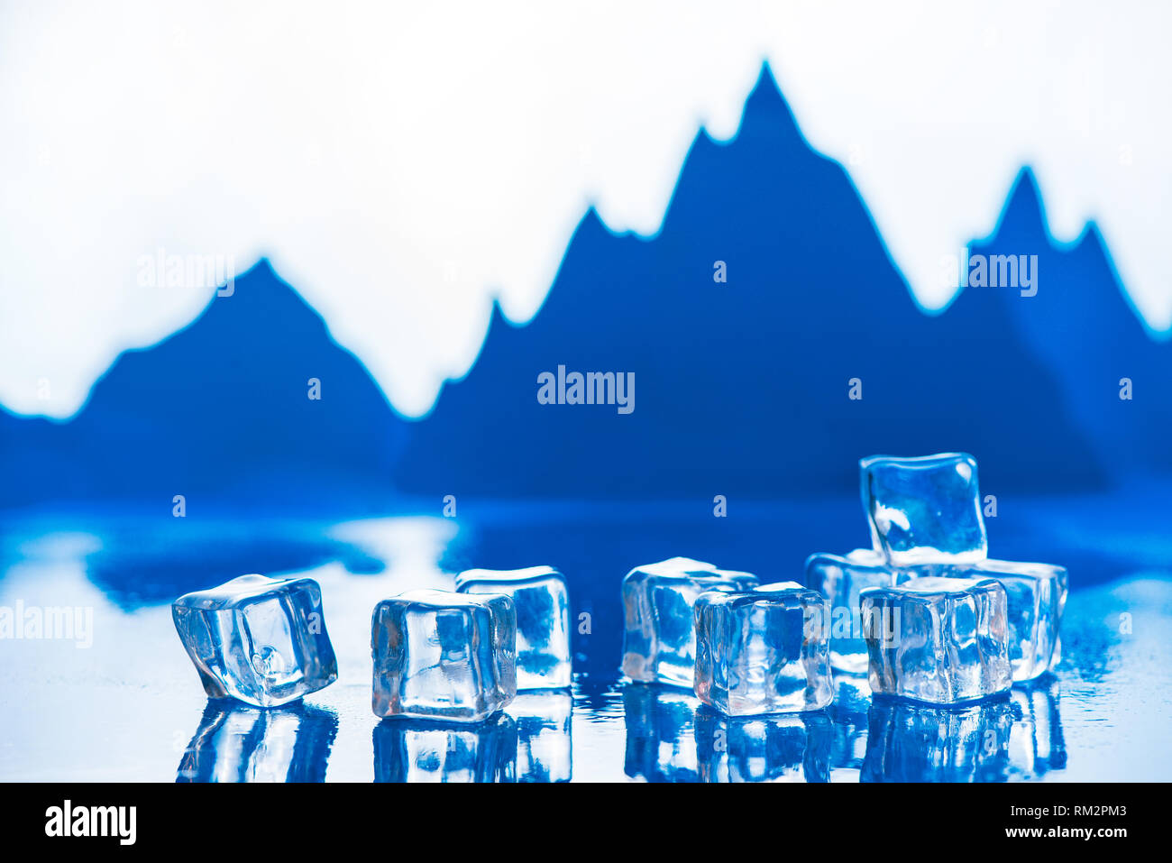 L'acqua chiara nozione con cubetti di ghiaccio e blu dei picchi di montagna sullo sfondo. Chiarezza e freddo con spazio di copia Foto Stock