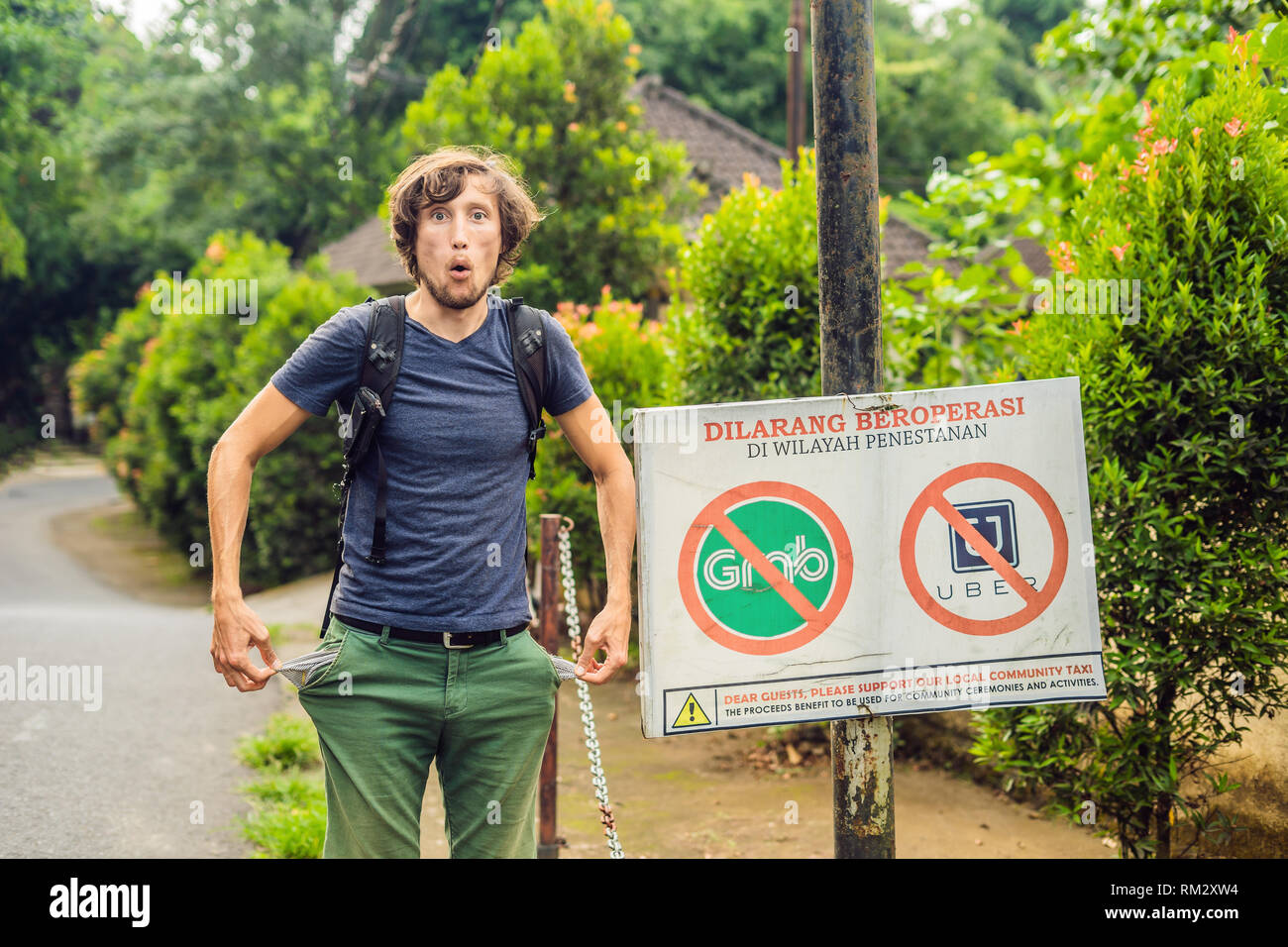 BALI, Indonesia - 21 Maggio 2018: il giovane uomo guarda in segno di protesta su una parete in indonesiano opponendosi alla Uber e afferrare i tassisti si legge 'uber e Grab Foto Stock