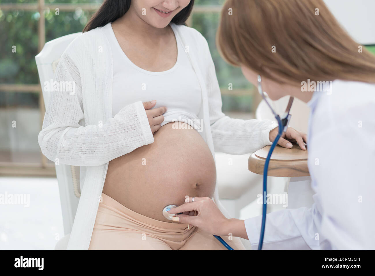Medico utilizzando la mano e stetoscopio esaminando bianco donna incinta in clinica,Medical Exam concetto. Foto Stock