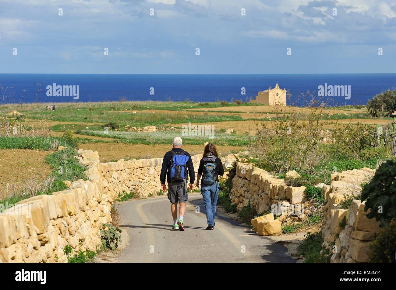 Ramblers su una strada di campagna che collega il villaggio di Gharb a San Dimitri cappella, Wied Il-Mielah, isola di Gozo, Malta, Mare mediterraneo, meridionale Foto Stock