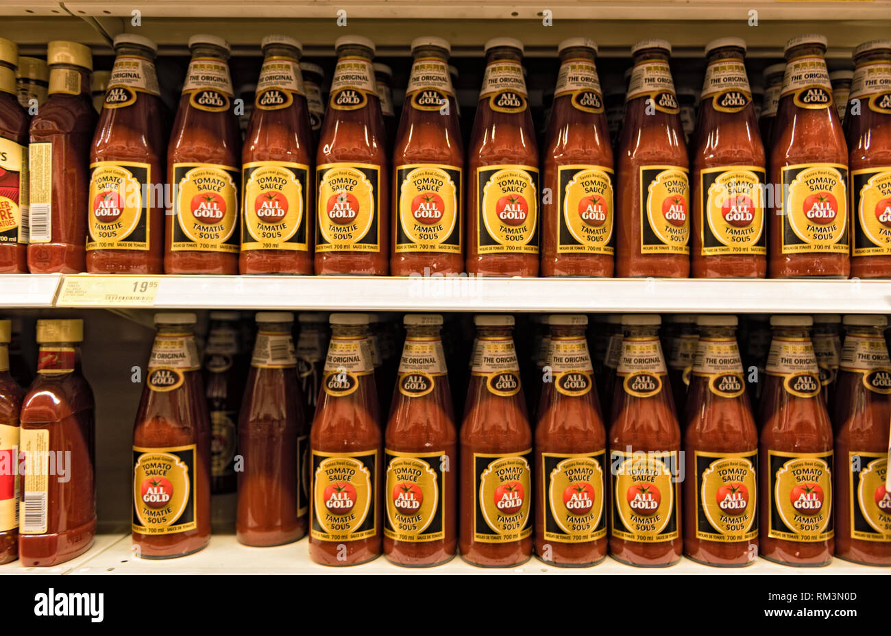 Uno scaffale di supermercato con tutti i gold tomato ketchup bottiglie Foto Stock