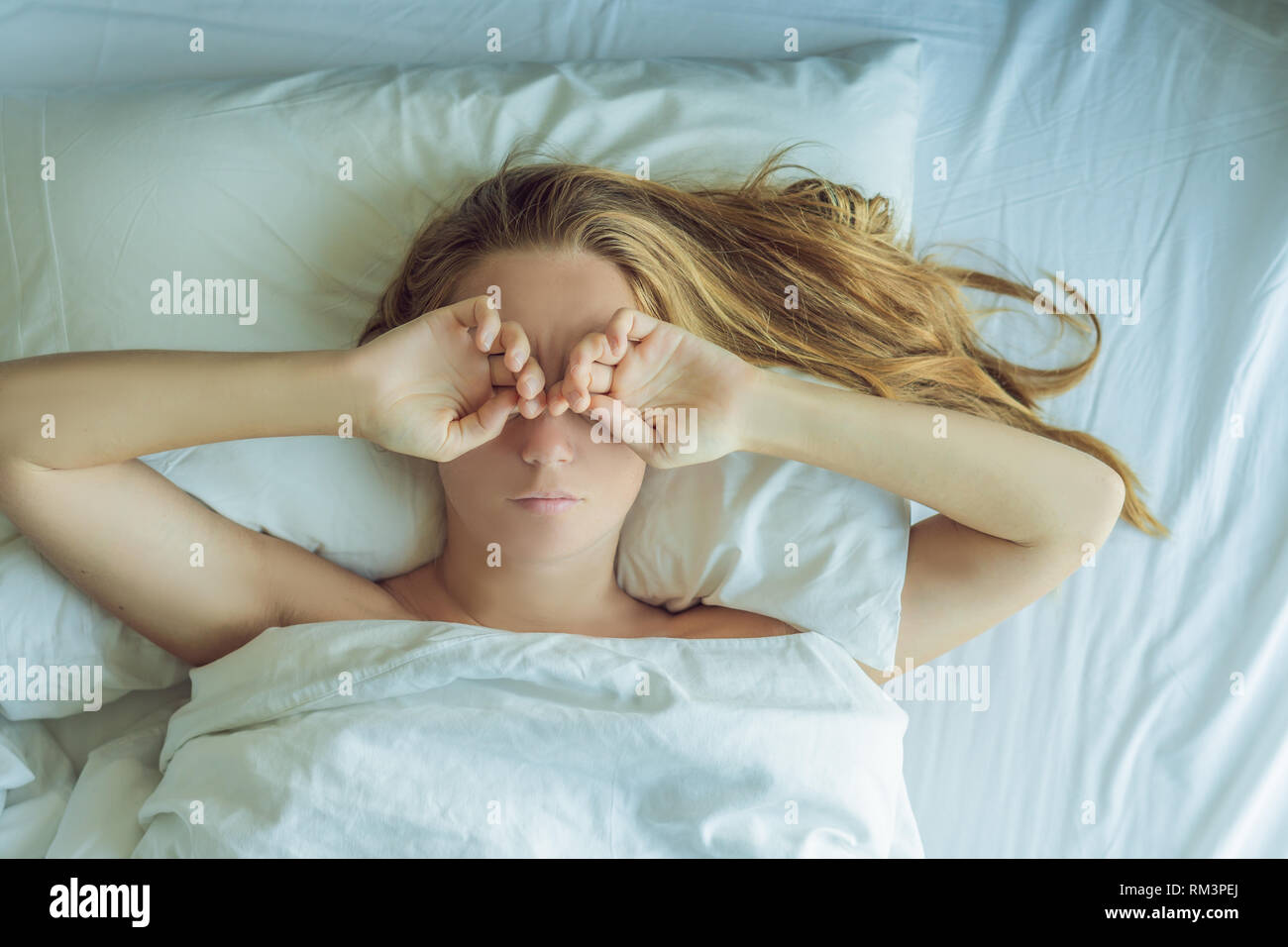Bella giovane donna sdraiata nel letto e dormire. Non ottenere abbastanza sonno concept Foto Stock