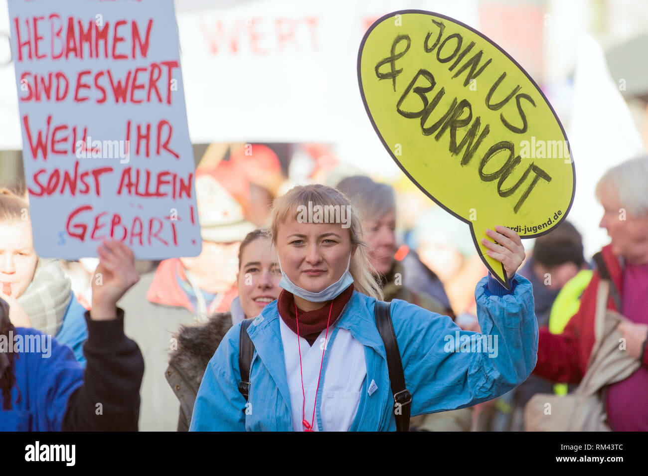 13 febbraio 2019, il Land della Baviera, Würzburg: Dimostrazione di infermieri prendere parte in un colpo di avvertimento di servizio pubblico in Würzburg. Essi detengono il poster come 'Midwives sono ne vale la pena perché altrimenti si darà la nascita da soli' e 'Join us & burn out'. Diverse centinaia di dipendenti dello Stato libero di Würzburg ha preso per le strade con la richiesta di un 6 per cento di aumento salariale. I dipendenti dell'ospedale universitario, le università e gli studenti nella più grande città della Bassa Franconia ha risposto ad una chiamata di sciopero del sindacato Verdi su mercoledì. Foto: Nicolas Armer/dpa Foto Stock