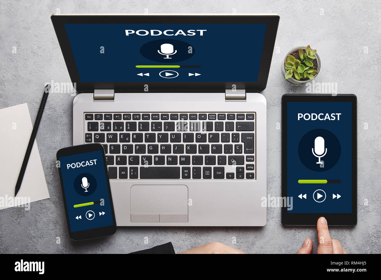 Concetto di podcast su laptop, tablet e lo schermo dello smartphone su tabella grigia. Tutti i contenuti della schermata è progettato da me. Lay piatto Foto Stock