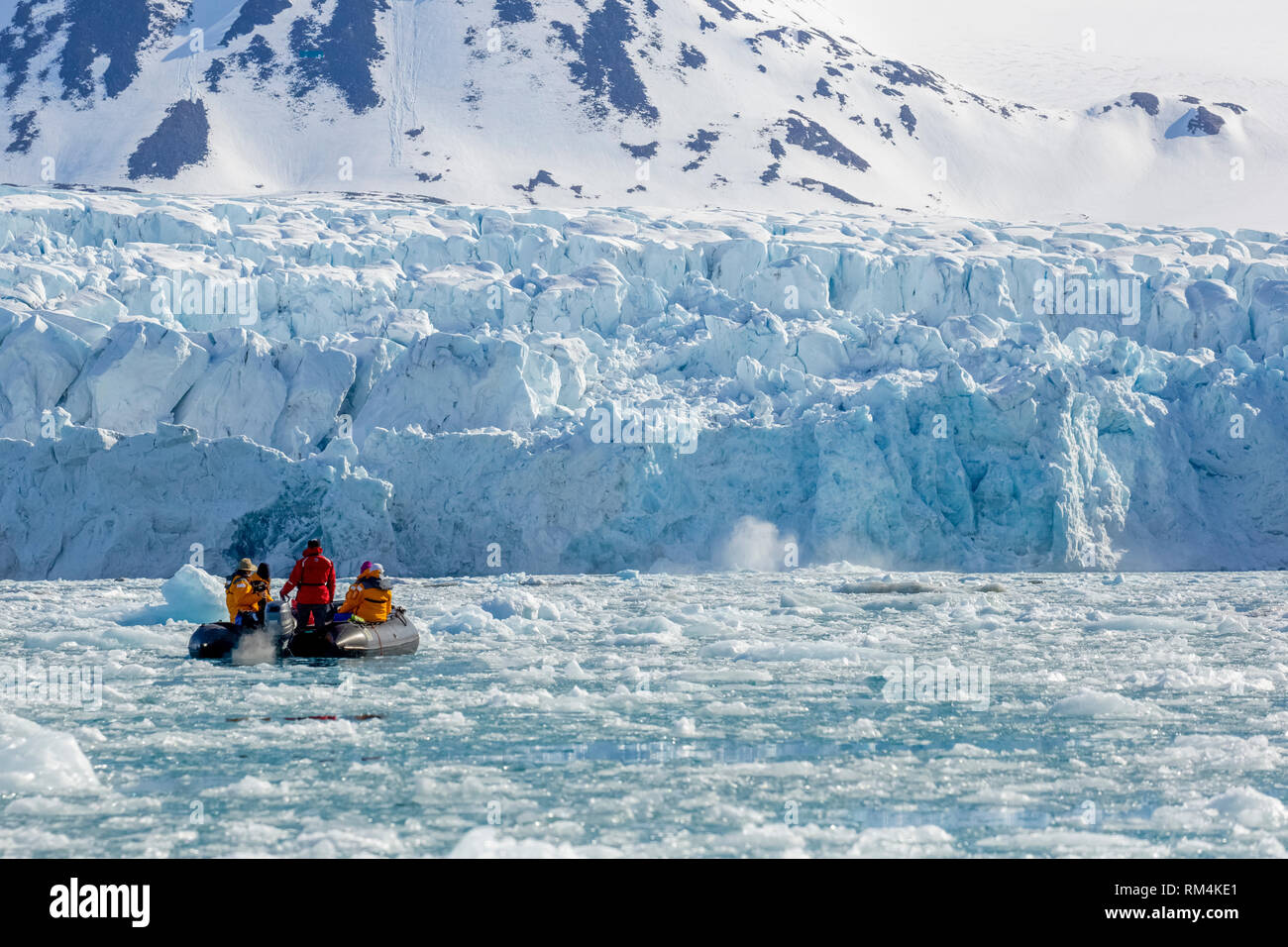 Crociera avventura passeggeri su una gomma zodiac squallido tour un iceberg in Spitsbergen, Norvegia in giugno Foto Stock