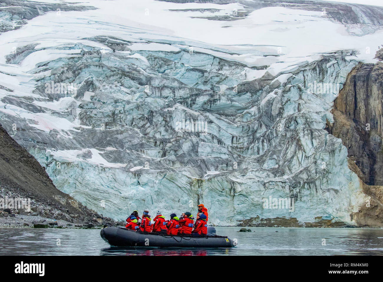 Crociera avventura passeggeri su una gomma zodiac squallido tour un iceberg in Spitsbergen, Norvegia in giugno Foto Stock