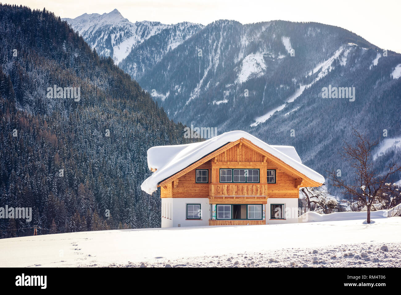 Bella solitaria casa in legno sullo sfondo di montagne innevate. Sci popolare regione Stiria, Austria Foto Stock