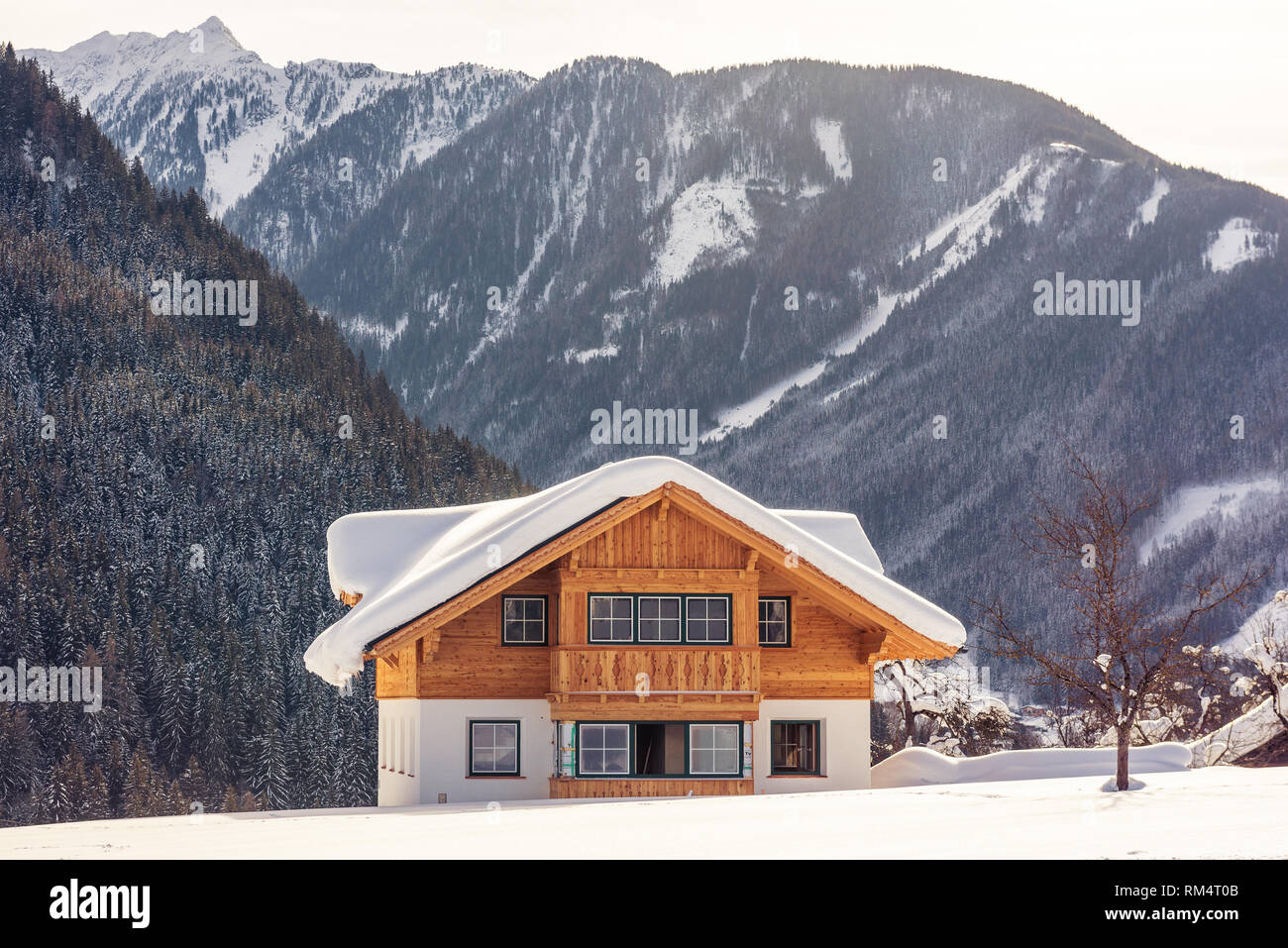 Bella solitaria casa in legno sullo sfondo di montagne innevate. Sci popolare regione Stiria, Austria Foto Stock