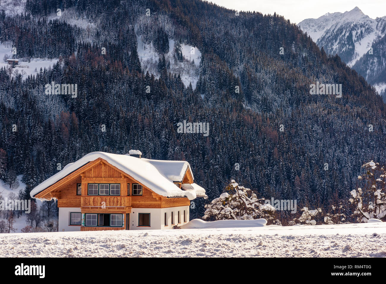 Bella solitaria casa in legno sullo sfondo di montagne innevate. Sci popolare regione Stiria, Austria Foto Stock