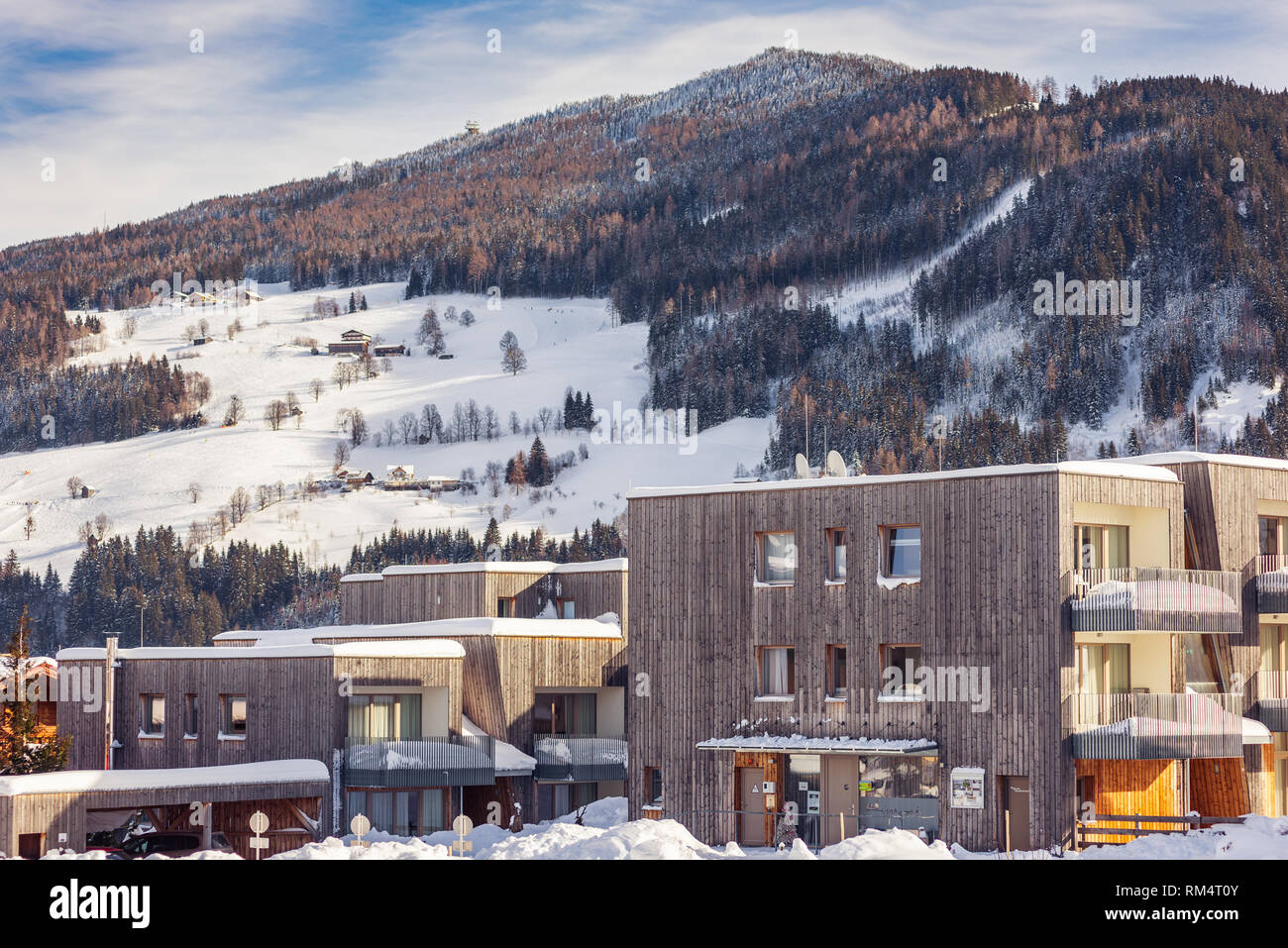 Moderna casa di montagna in inverno con montagne innevate sullo sfondo nella regione sciistica di Schladming-Dachstein, Liezen District, Stiria, Austria Foto Stock