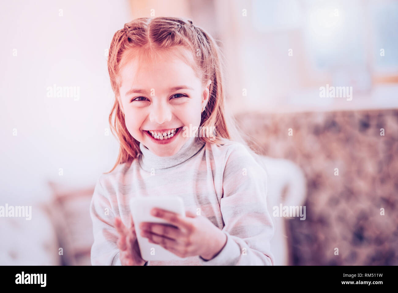 Bambino in età prescolare ridere durante la lettura divertente storia Foto Stock