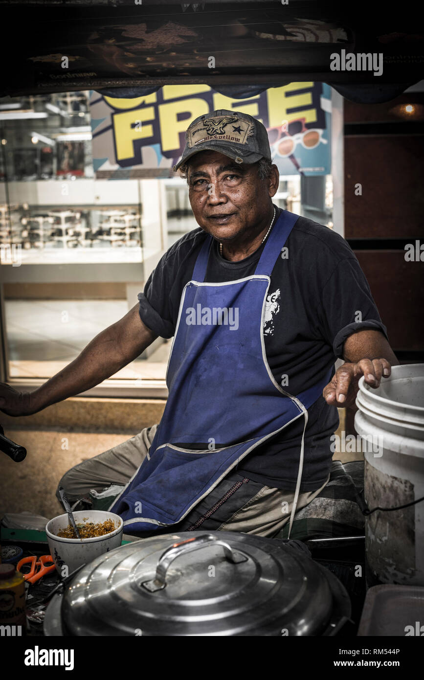 Venditore ambulante di vendita di alimenti da uno stallo in un mercato a Phuket, Tailandia. Foto Stock