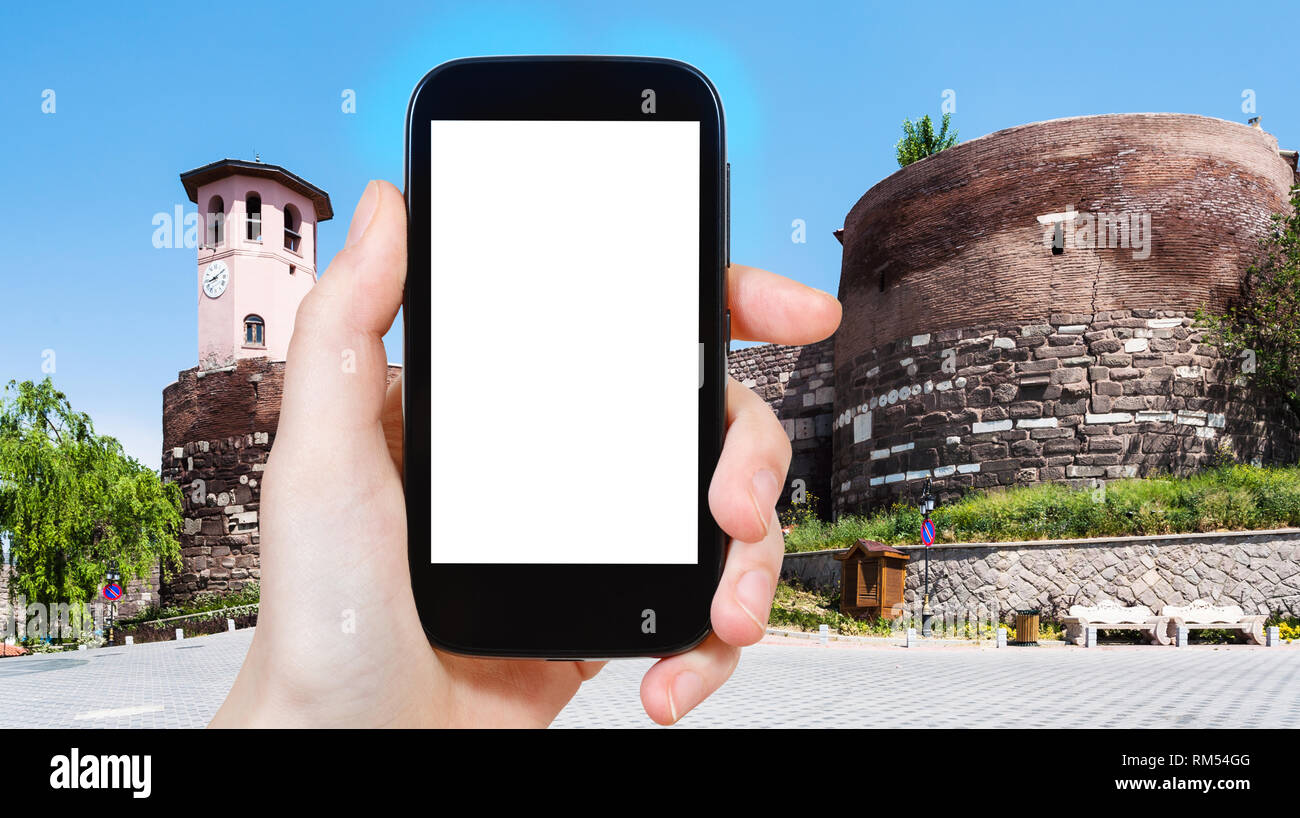 Concetto di viaggio - tourist fotografie di gate al vecchio castello di Ankara sulla piazza Gozcu in Turchia su smartphone con esclusione vuoto con schermo vuoto posto fo Foto Stock