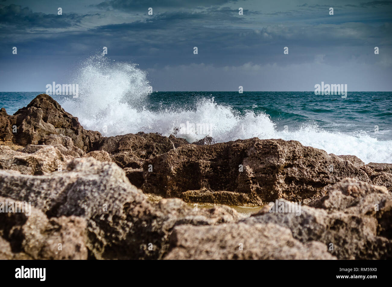 Onde che si infrangono sulle rocce Foto Stock