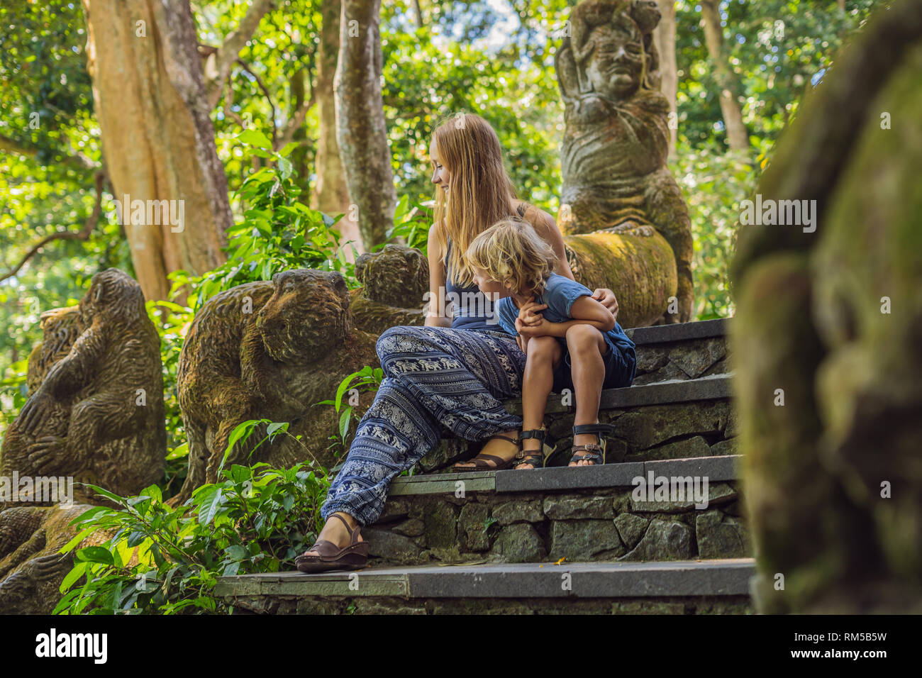 Madre e figlio i viaggiatori alla scoperta della foresta Ubud nella foresta delle scimmie, Bali Indonesia. Viaggiare con bambini di concetto Foto Stock