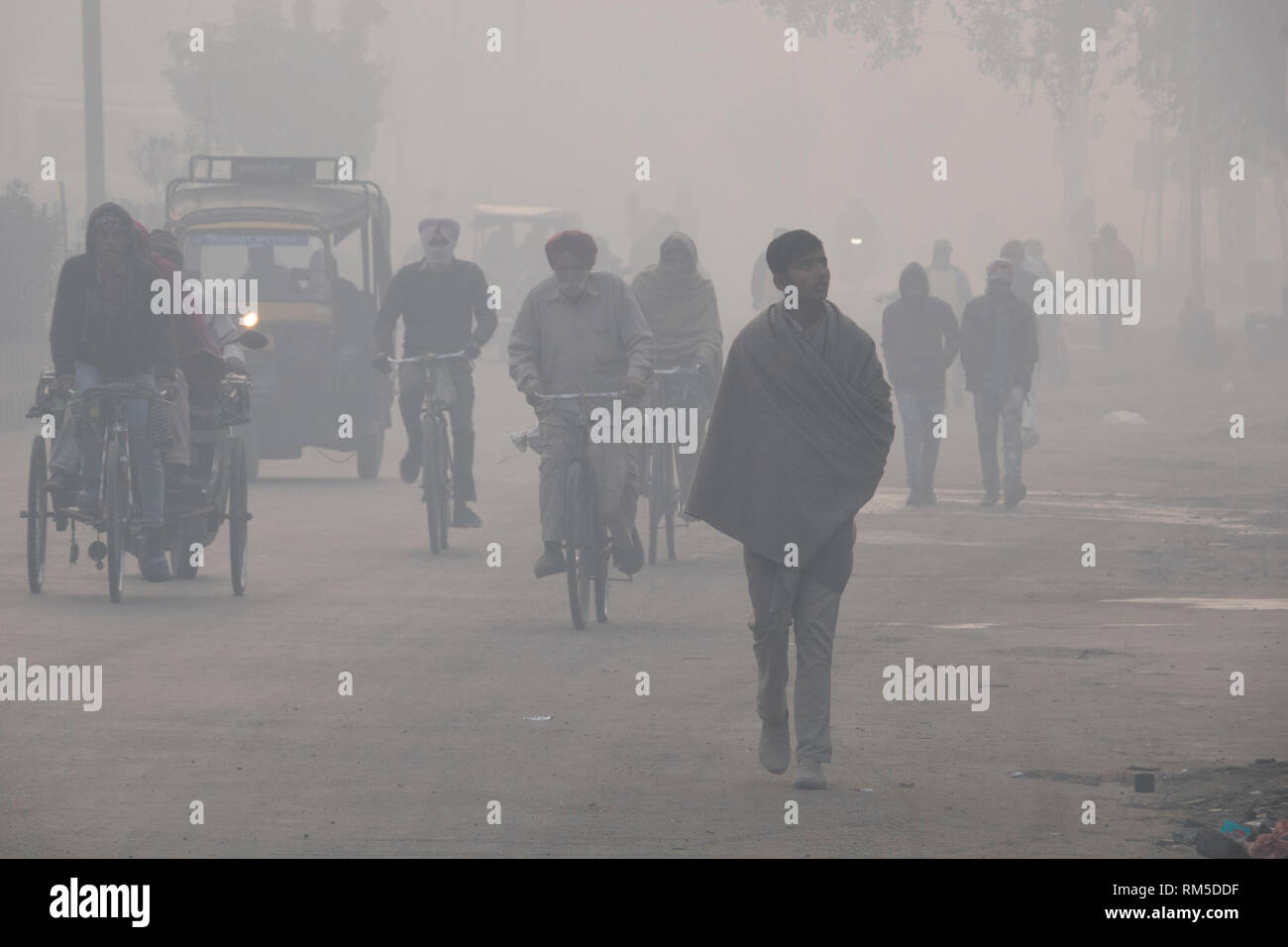 La mattina presto pendolari in livelli pericolosi di inquinamento atmosferico di Amritsar, India Foto Stock
