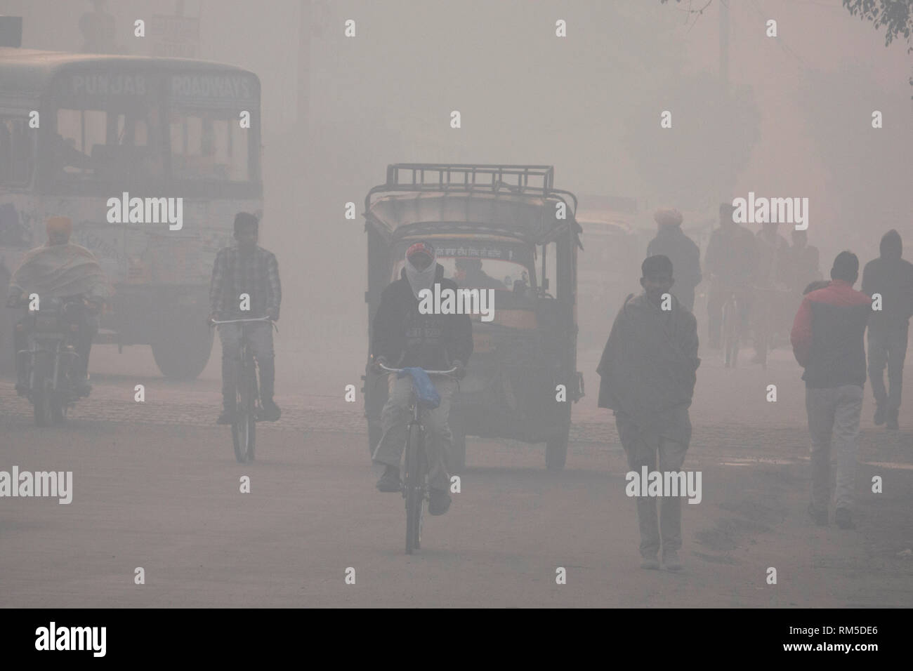 La mattina presto pendolari in livelli pericolosi di inquinamento atmosferico di Amritsar, India Foto Stock