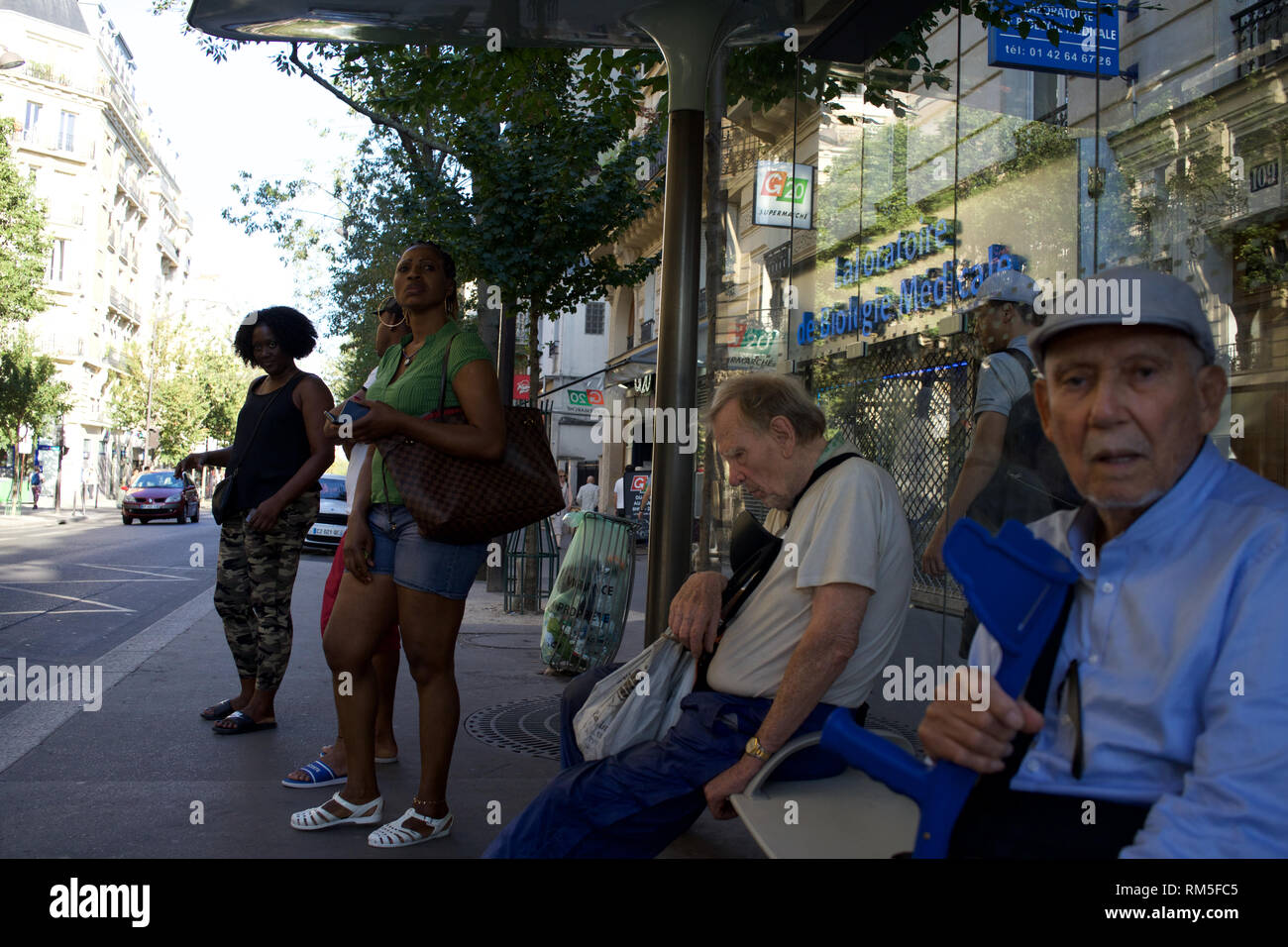 I passeggeri in attesa alla fermata del bus, gli uomini vecchi con bastoni da passeggio, handicappati, invalidi, boulevard Ornano, 75018 Parigi, Francia Foto Stock