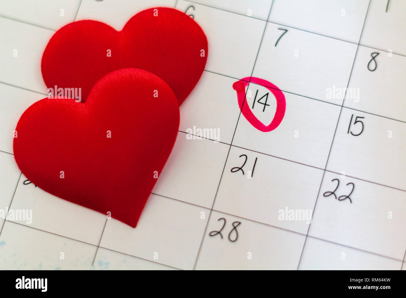 Foglio di calendario con marcata 14 febbraio data e rosso a forma di cuore di cioccolatini Foto Stock