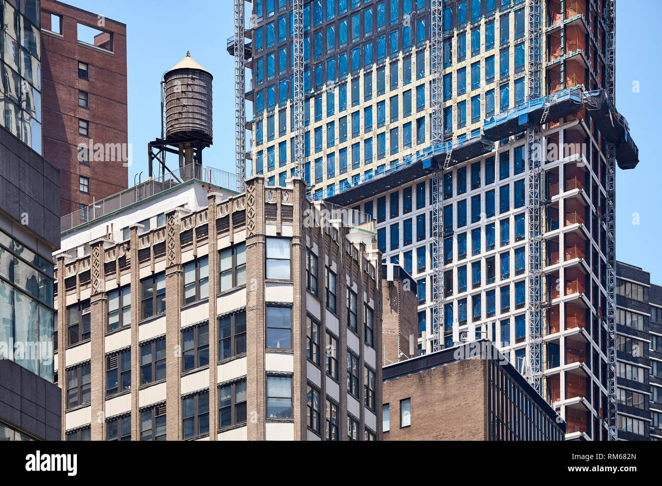 Serbatoio di Acqua su un vecchio edificio circondato da moderni grattacieli nel centro di New York, Stati Uniti d'America. Foto Stock