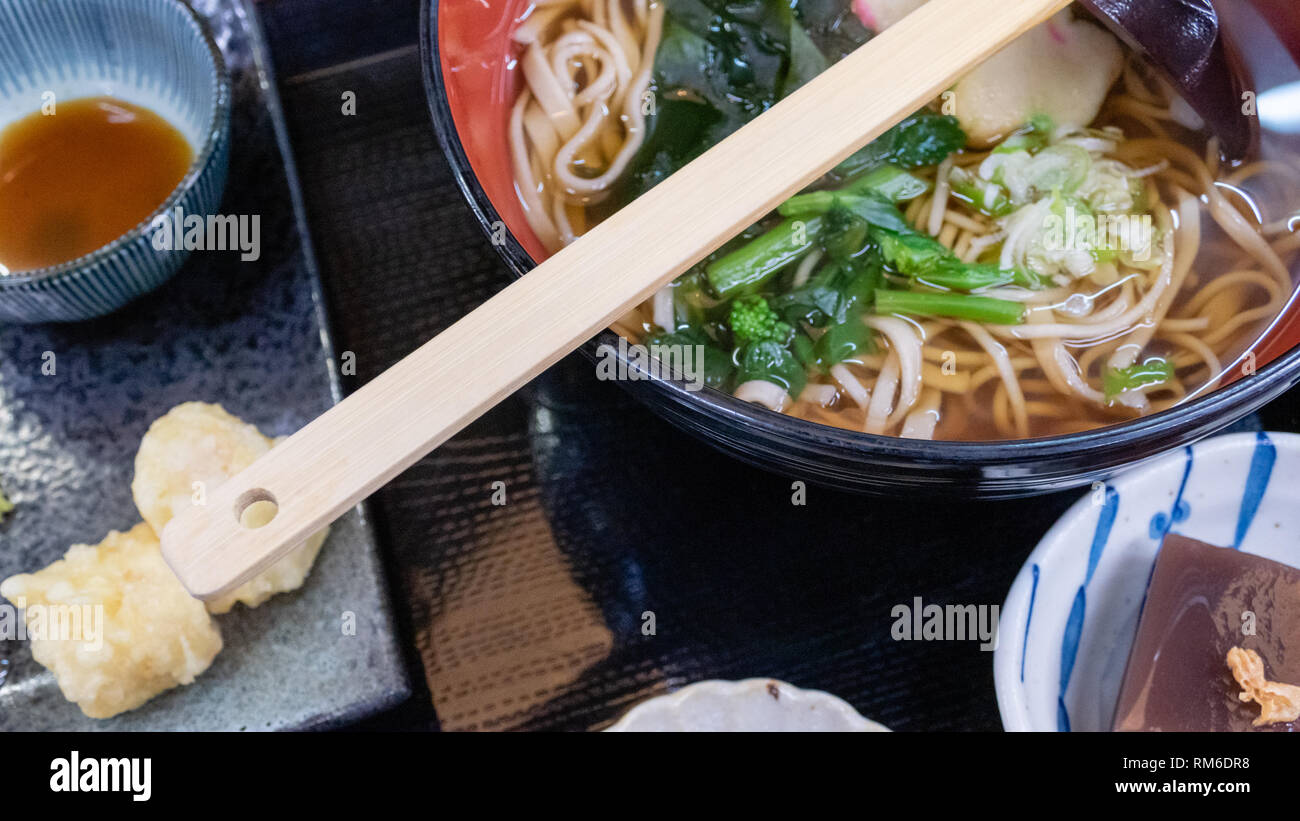 Udon spaghetti di grano con zuppa calda, rotolo di latte di soia, pelle e tempura Foto Stock