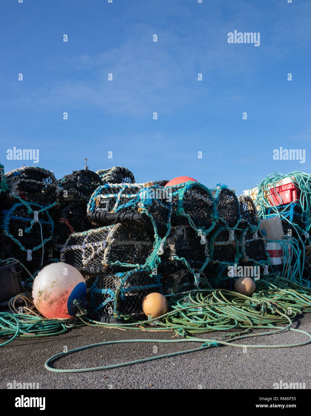 Le reti da pesca e la corda con il granchio bicchieri impilati su una banchina Foto Stock