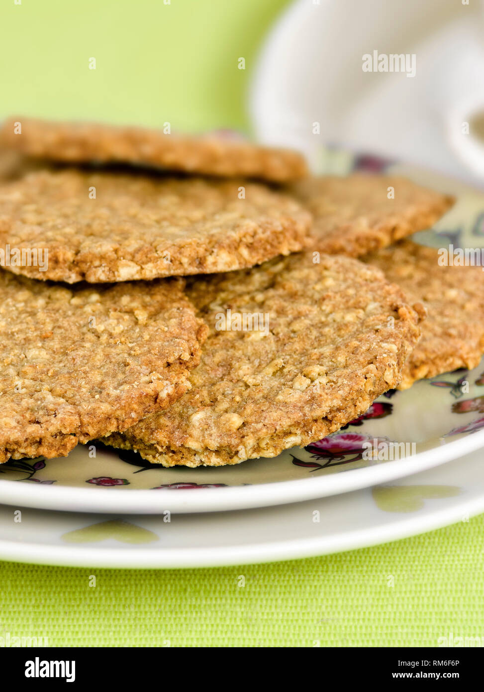 Appena sfornato digestivi fatti in casa i biscotti sulla piastra contro uno sfondo verde Foto Stock