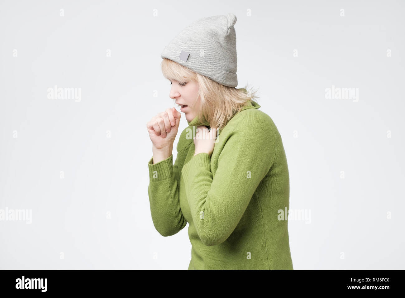 Malsana giovane donna bionda a tossire troppo, la sofferenza con tosse, ha un dolore toracico Foto Stock